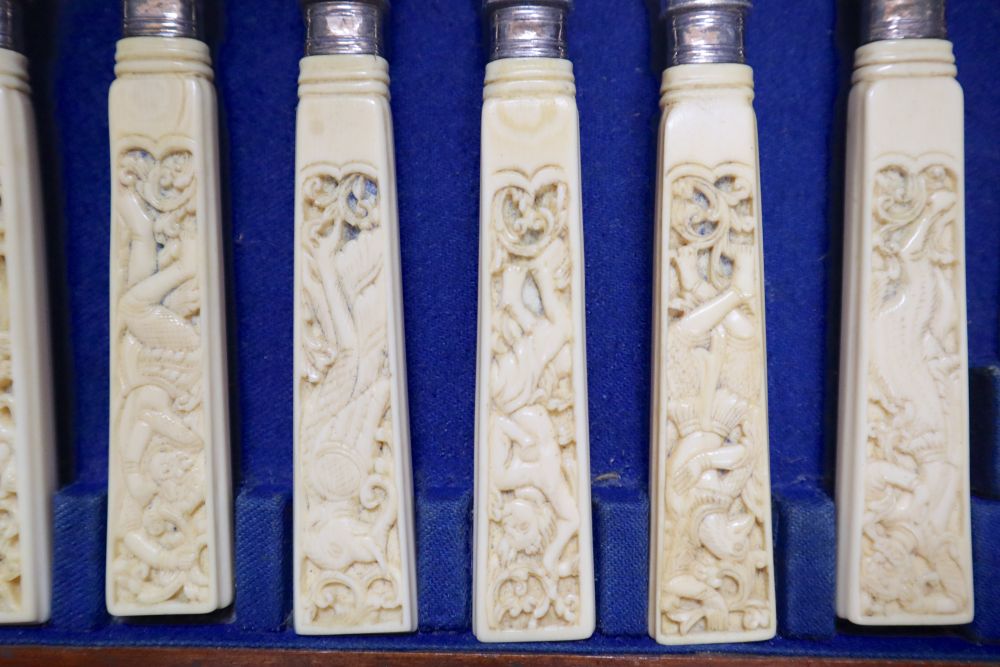 A Victorian set of twelve plated and engraved fish knives and forks, with carved ivory handles, mahogany cased